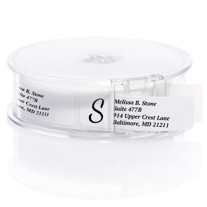 A roll of white address labels with a prominent black letter S initial monogram, neatly packaged in a clear, round plastic dispenser.