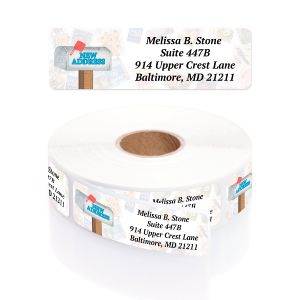 Unrolled Just Moved return address label featuring a blue New Address signpost graphic next to a coiled roll of personalized address labels.