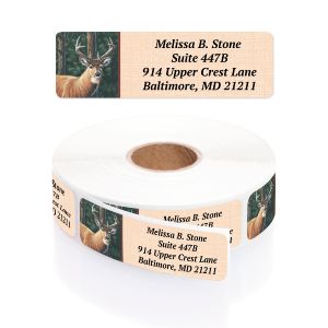 A rectangular personalized address label displayed above a large roll of matching labels, featuring a majestic buck in a forest setting.