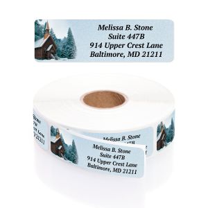 A personalized return address label with a serene graphic of a cozy church in the snow, shown above its matching label roll.