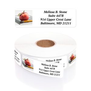 A paper roll of An Apple A Day address labels showcasing a realistic red apple illustration on a desk layout beside a clean typography template.