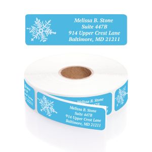Roll of blue Crystal Noel address labels featuring white snowflake graphics alongside personalized custom printed return address text.