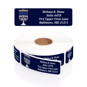 A roll of dark blue Hanukkah address labels with a menorah illustration and white personalized text.