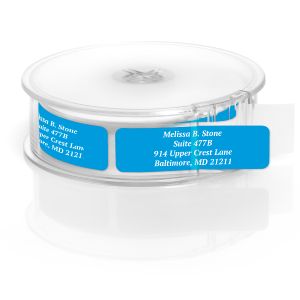 A paper roll of vibrant blue address labels featuring a crisp white typography layout template, housed inside a clear round plastic dispenser.