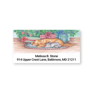 Rectangular holiday address label featuring a sleeping dog and cat under a Christmas tree with wrapped gifts and custom address text.
