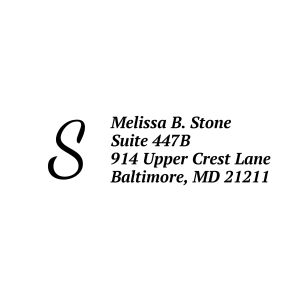A crisp black impression of a personalized address stamp, showing a large serif monogram initial next to a clean, four-line custom address.