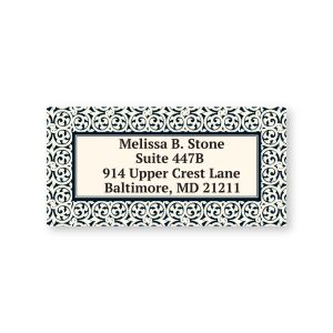 A close-up of a personalized return address label featuring an intricate black and white scrollwork border design around the text.