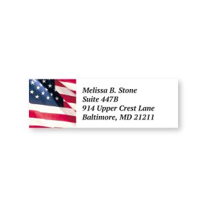 A rectangular personalized address label showcasing a vibrant, waving American flag on the left with custom printed text on the right.