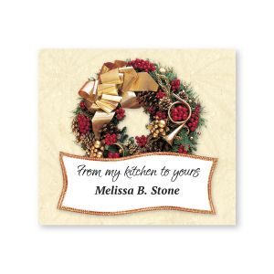 Festive holiday goodie label featuring a detailed Christmas wreath with red berries, pinecones, and a gold bow above custom text.