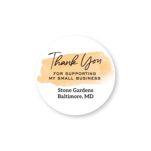 Round sticker featuring an orange watercolor accent, reading 