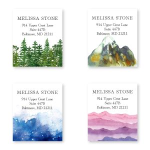 Four rectangular personalized address labels showcasing artistic watercolor nature landscapes: green trees, a mountain, night sky, and pink hills.
