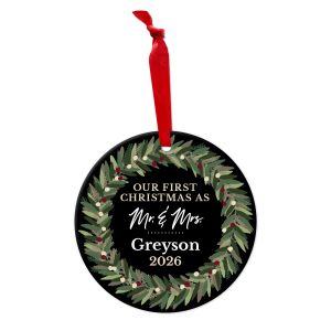 Round metal Christmas ornament with red ribbon, magnolia wreath, and text reading 