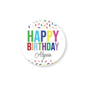 Round personalized birthday sticker with colorful sprinkles, bold text reading HAPPY BIRTHDAY, and custom script name Alyssa on a white background.