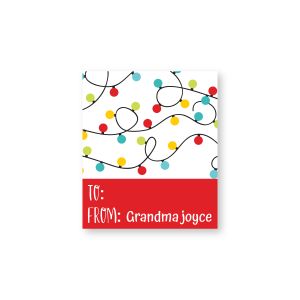 Rectangular gift tag label featuring colorful Christmas string lights above a red box reading 