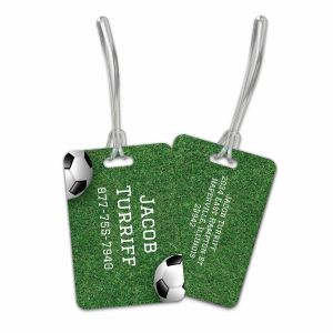Rectangular plastic luggage tag featuring a soccer field graphic, soccer ball, and custom text 
