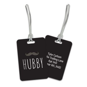 Double-sided black plastic luggage tag featuring a mustache graphic above bold white HUBBY text alongside custom contact info on the back.