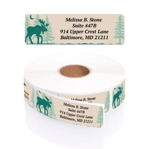 A paper roll of rustic address labels featuring a dark teal moose silhouette, a crescent moon, and pale trees on a cream-colored background.