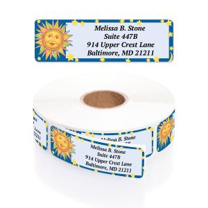 A rectangular personalized address label displayed above a large roll of matching labels, featuring a vibrant sun graphic on a blue starry sky.