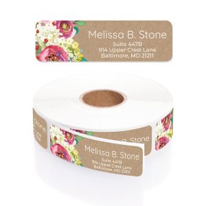 A personalized return address label with a rustic brown kraft background and a vibrant watercolor floral corner, shown with its matching roll.