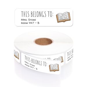 A roll of personalized classroom name labels with an open book design, in a clear plastic dispenser with a close-up graphic overlay.