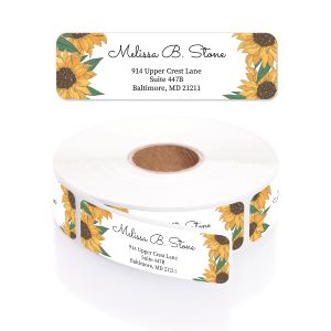 A rectangular personalized address label displayed above a large roll of the same labels, featuring a vibrant yellow sunflower design on the edges.