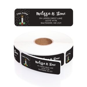 A paper roll of black holiday address labels featuring a lit Christmas candle graphic and an elegant cursive layout on a white background.