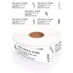 A paper roll of Black and White Floral address labels showcasing a dainty wildflower illustration beside a clean four-line typography layout.
