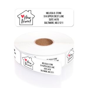 A roll of Red Heart New Home personalized address labels featuring a small house graphic, custom name, and address text.