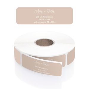 A large roll of muted tan address labels featuring an elegant cursive font for names and a clean, minimalist layout with modern block text.
