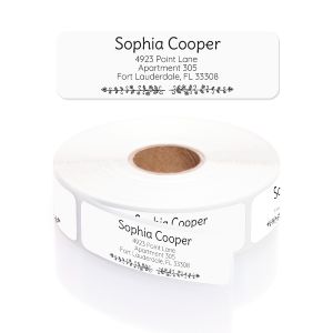 Close-up view of a roll of personalized Black and White Botanical address labels featuring delicate leafy vine illustrations along the border.