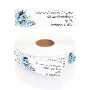 A close-up of a white rolled address label featuring a beautiful watercolor blue floral bouquet on the left and elegant, cursive text.