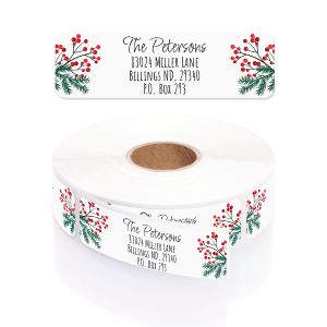Single personalized address label with pine tree and holly berry artwork displayed above a rolled coil of return address labels.