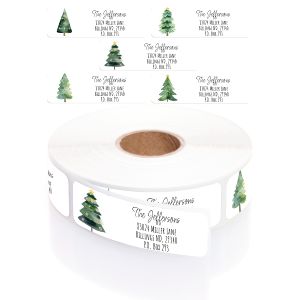 A rectangular personalized address label displayed above a large roll of matching labels, featuring a festive, soft watercolor holiday tree.
