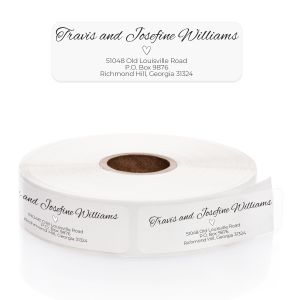 A personalized clear return address label with an elegant minimalist line-art heart and script font, shown above its matching roll.