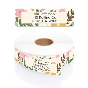 A rectangular personalized address label displayed above a large roll of matching labels, featuring a soft pastel pink and green floral border.