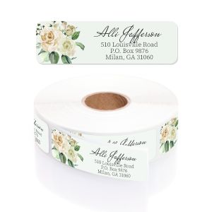 A rectangular personalized address label displayed above a large roll of matching labels, featuring a delicate cream and green watercolor floral design.