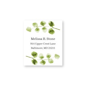 A close-up of a square address label featuring delicate, soft green watercolor eucalyptus branches flanking a clean, modern text layout.
