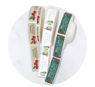 Continuous rolls of custom Christmas address labels featuring festive green holiday tree designs and typography.